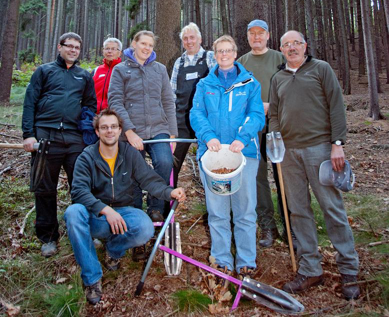 Das Team der Skischule im Wald beim Bäume pflanzen.